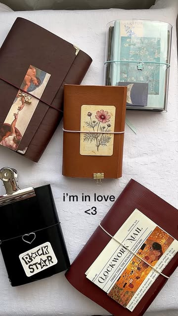A collection of leather journals with botanical labels, artwork, charms and elastic closures